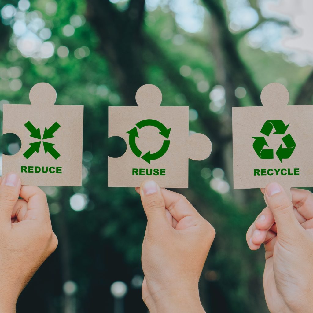 Hand holding Jigsaw with reduce, reuse, recycle symbol.Ecological waste management and a sustainable